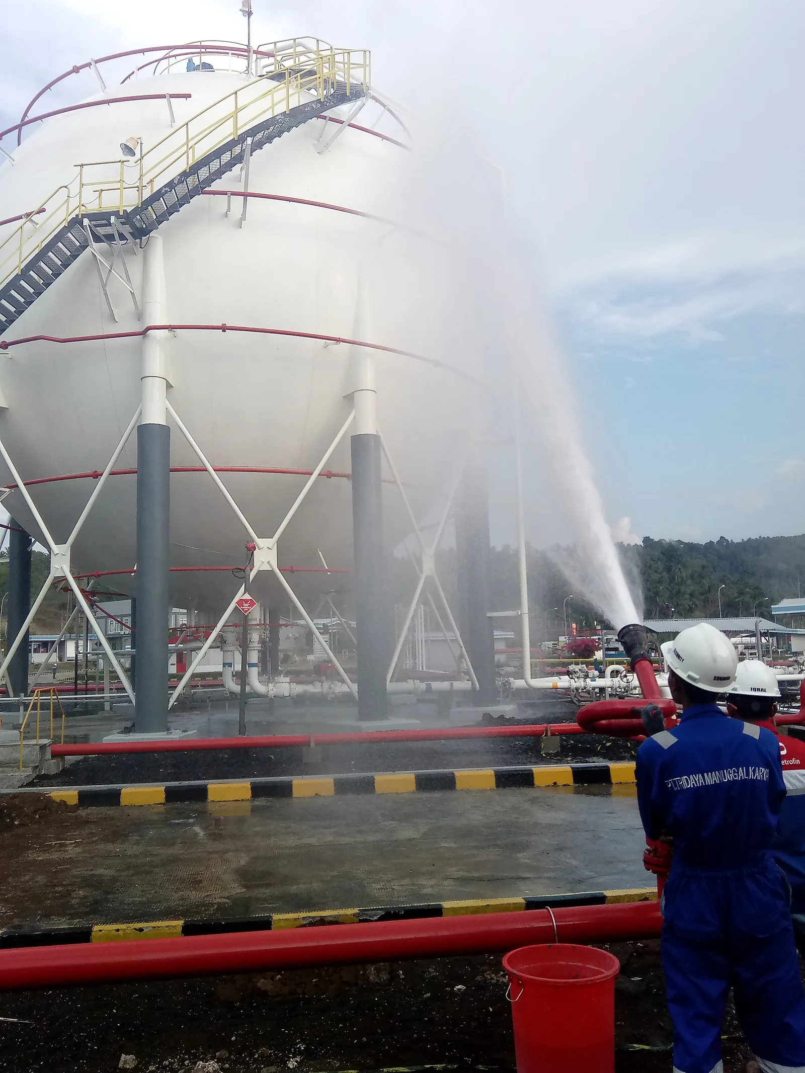 Fire monitor discharging over an LPG storage sphere during commissioning at Amurang